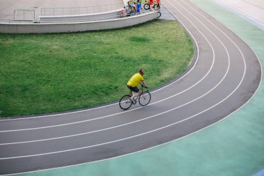 Bir adam stadyumda bisiklet sürüyor.