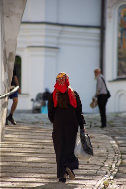 Kiev Pechersk Lavra 'nın arka planında eşarplı Ortodoks kadın