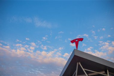 Tesla elektrikli araba şirketi logosu binanın çatısında.