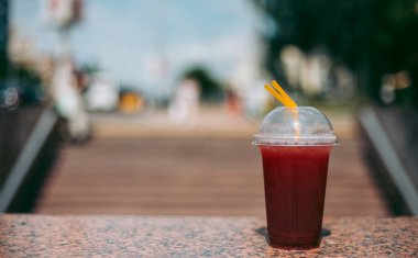 Plastik bardakta pipetle kırmızı ahududu içeceği.