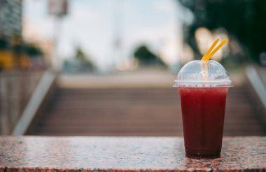 Plastik bardakta pipetle kırmızı ahududu içeceği.