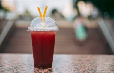 Plastik bardakta pipetle kırmızı ahududu içeceği.