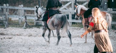 Ortaçağ kıyafetleri içinde at sırtında bir adam.