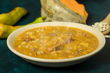 Bir tabak locro. Mavi bir masada geleneksel Arjantin yemeği