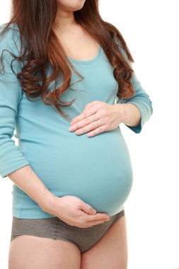  Kadın büyüyen hamile karnına dokunuyor.