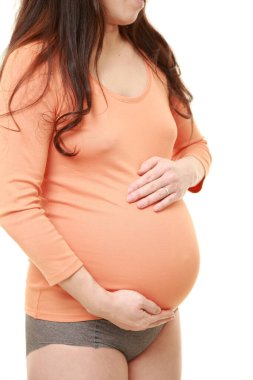  Kadın büyüyen hamile karnına dokunuyor.