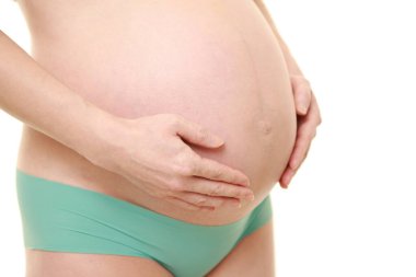  Kadın büyüyen hamile karnına dokunuyor.