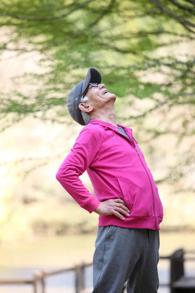 Senior Japonés Hombre Rosa Desgaste Haciendo Ejercicio Físico Pie Espalda —  Fotos de Stock