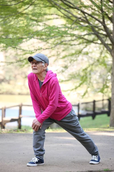 Senior Japonais Homme Dans Sweat Capuche Faire Jambe Étirer Extérieur — Photo