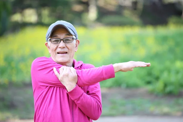 Старший Японець Рожевій Парці Простягає Руку Відкритому Повітрі — стокове фото