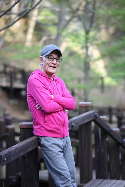 Doğal Parkın Ahşap Güvertesinde Kapüşonlu Kıdemli Japon Adam — Stok fotoğraf