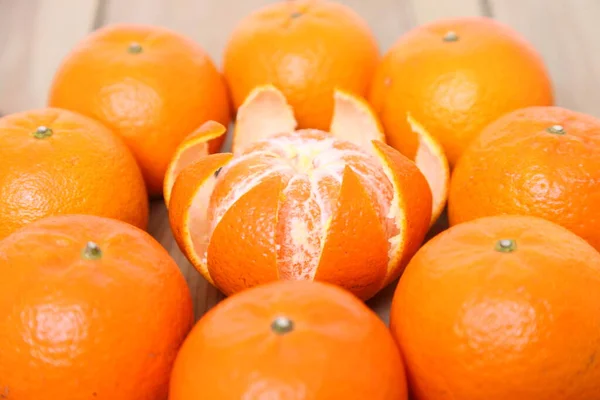 peeled orange fruit citrus tankan against wooden background