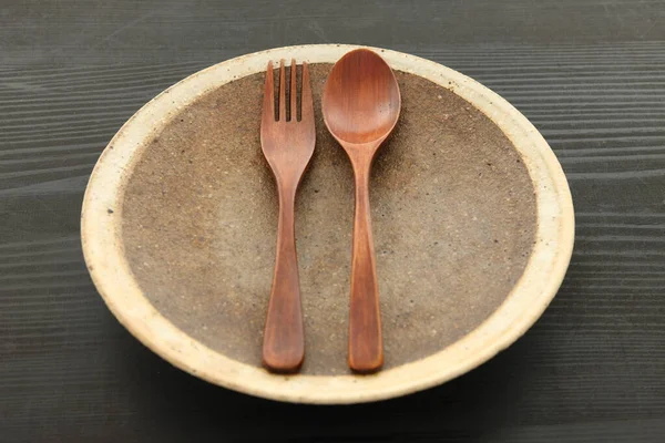 饭桌上有木制餐具的空粘土盘 — 图库照片