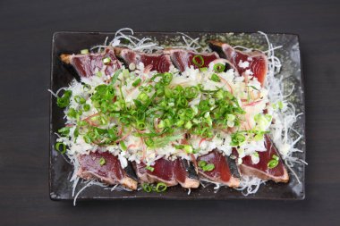 Hafif kızarmış soğanlı bonito sashimi.