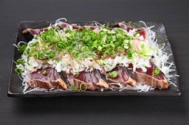 Hafif kızarmış soğanlı bonito sashimi.