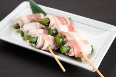 Pişmemiş domuz eti ve kuşkonmaz sarması.