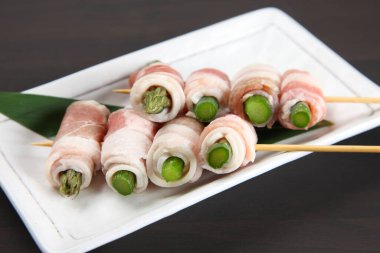 Pişmemiş domuz eti ve kuşkonmaz sarması.