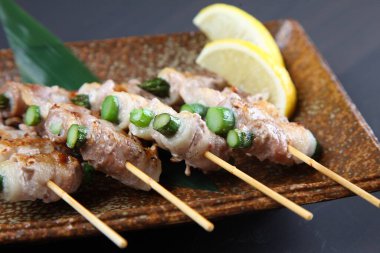 Domuz ve kuşkonmaz şiş sarıyor.