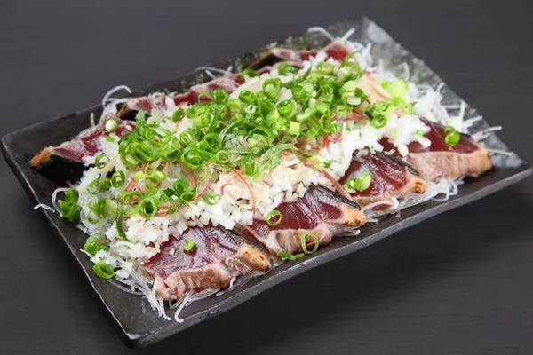Hafif kızarmış soğanlı bonito sashimi.