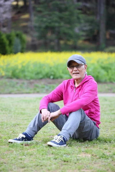 Pembe Elbiseli Yaşlı Japon Bir Adam Çimenlerde Oturuyor — Stok fotoğraf