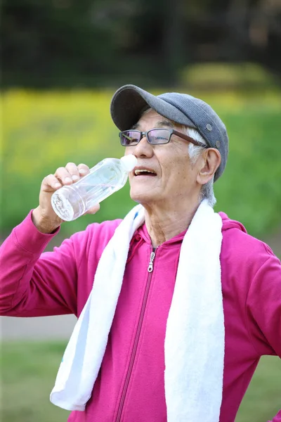 Старший Японець Рожевому Одязі Пітніє Спраглий Після Вправ Воду Надворі — стокове фото