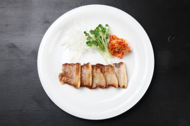 İnce dilimlenmiş domuz pirzolası ve kimchi.