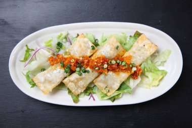 Baharatlı sosa etli börek koy.