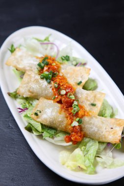 Baharatlı sosa etli börek koy.