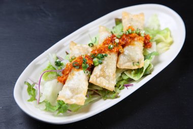 Baharatlı sosa etli börek koy.