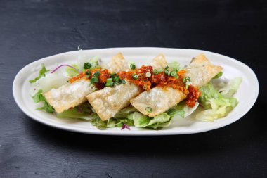 Baharatlı sosa etli börek koy.