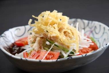 Koyu arkaplanda turp salatası olan tavuk