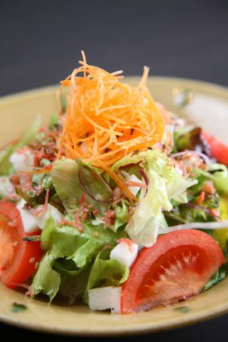 Siyah arka planda tatlı patates ve erik salatası.