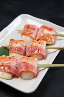 Domuz pastırması ve pirinç keki şişleri.