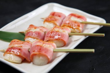 Domuz pastırması ve pirinç keki şişleri.