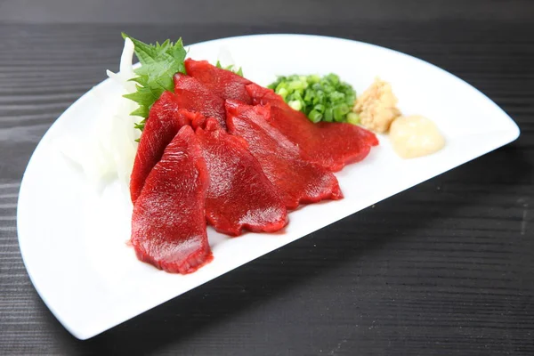 Yeşil soğanlı at eti sashimi.