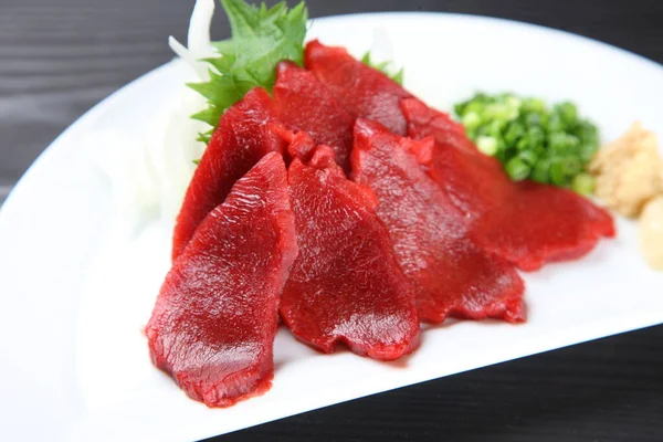 Yeşil soğanlı at eti sashimi.
