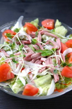 Siyah arka planda kızarmış et salatası.