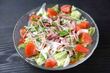 Siyah arka planda kızarmış et salatası.