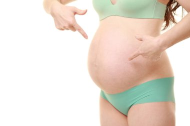 Hamile kadın karnını işaret ediyor.