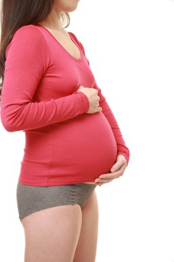  Kadın büyüyen hamile karnına dokunuyor.