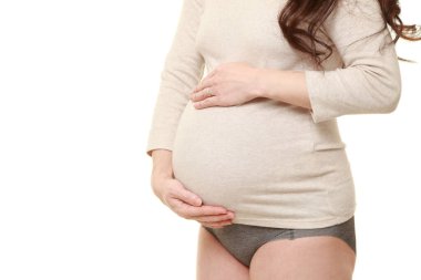  Kadın büyüyen hamile karnına dokunuyor.