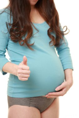 Başparmakları havada hamile bir kadın.