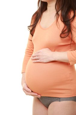  Kadın büyüyen hamile karnına dokunuyor.