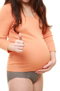 Başparmakları havada hamile bir kadın.