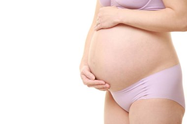  Kadın büyüyen hamile karnına dokunuyor.