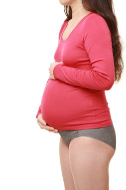  Kadın büyüyen hamile karnına dokunuyor.