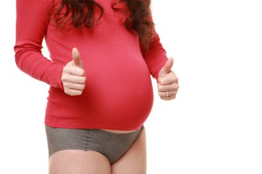 Başparmakları havada hamile bir kadın.