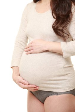  Kadın büyüyen hamile karnına dokunuyor.