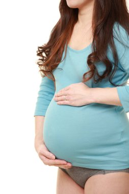  Kadın büyüyen hamile karnına dokunuyor.