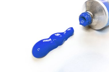 Mavi akrilik boya açık tüp ve beyaz yüzeyüzerinde ekstrüde boya. Sanatçı ve okul sanat malzemeleri beyaz izole. Renkli ve şık illüstrasyon. Yeni bir sanat eserine başlamaya hazırlanıyor.